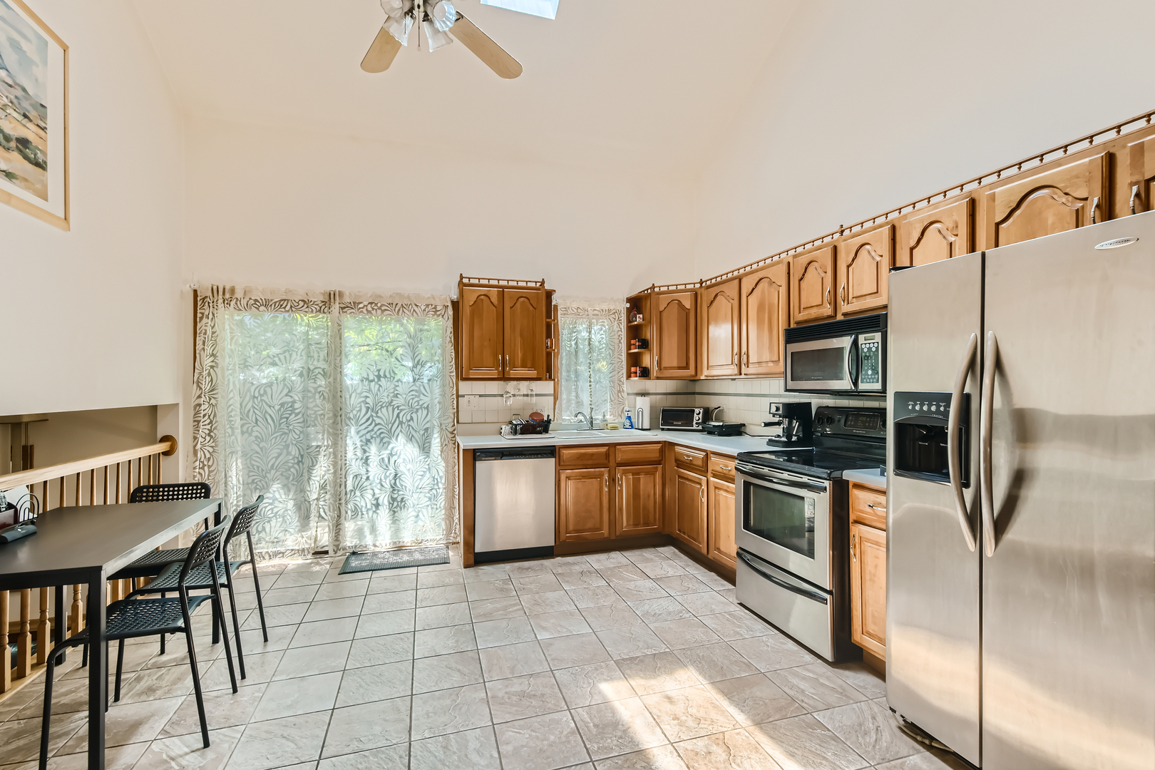 4057 Custer Avenue Lyons, IL 60534 - Photo 9 of 28 a kitchen with stainless steel appliances granite countertop a stove top oven a sink dishwasher a dining table and chairs with wooden floor