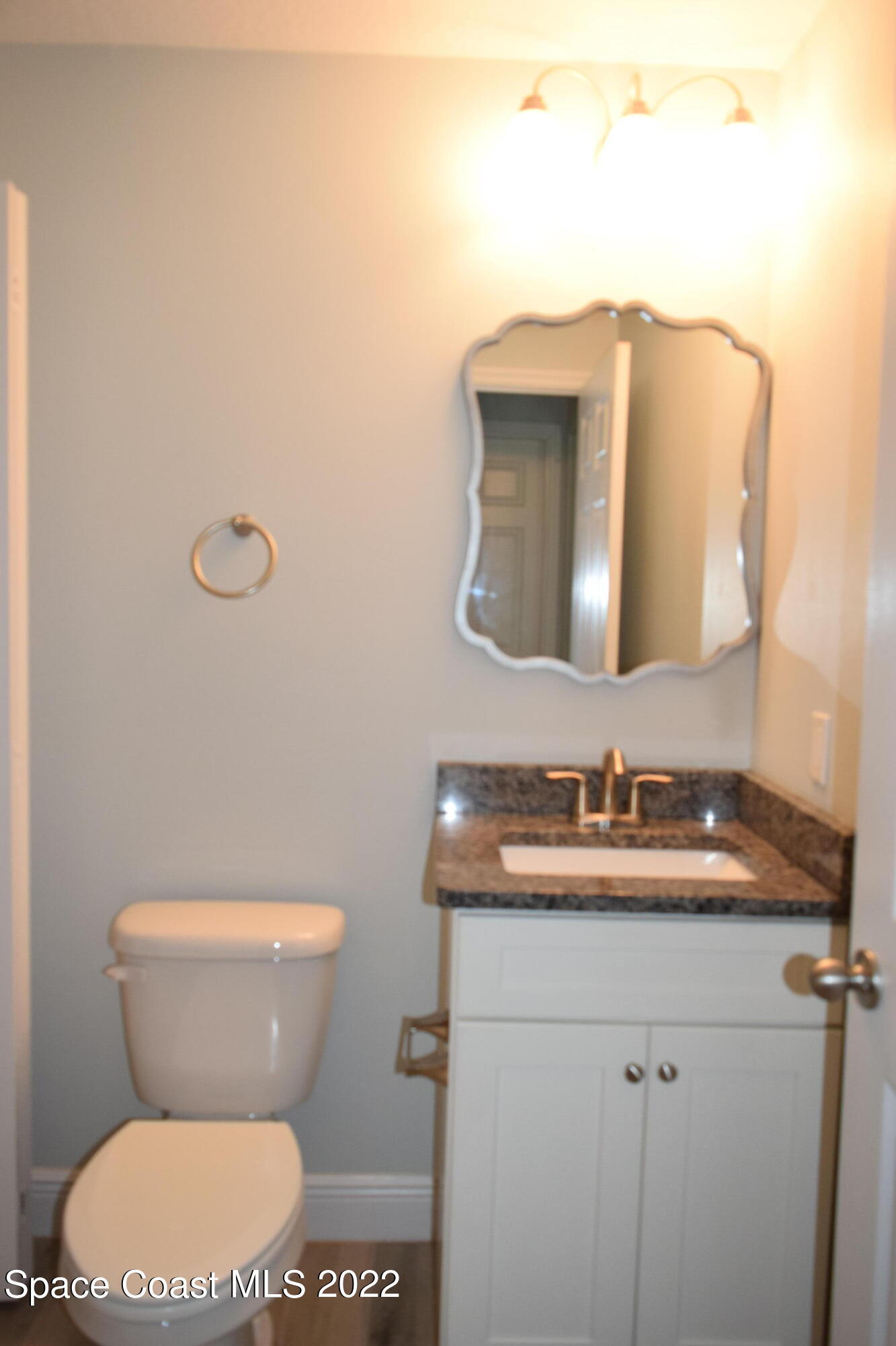 1328 Hazel Street Northwest Palm Bay, FL 32907 - Photo 20 of 28 a bathroom with a toilet sink and mirror
