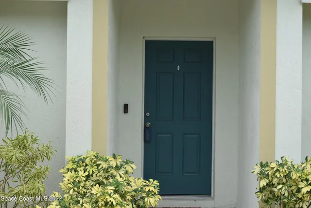 a view of a kitchen with a sink wooden floor and an empty room