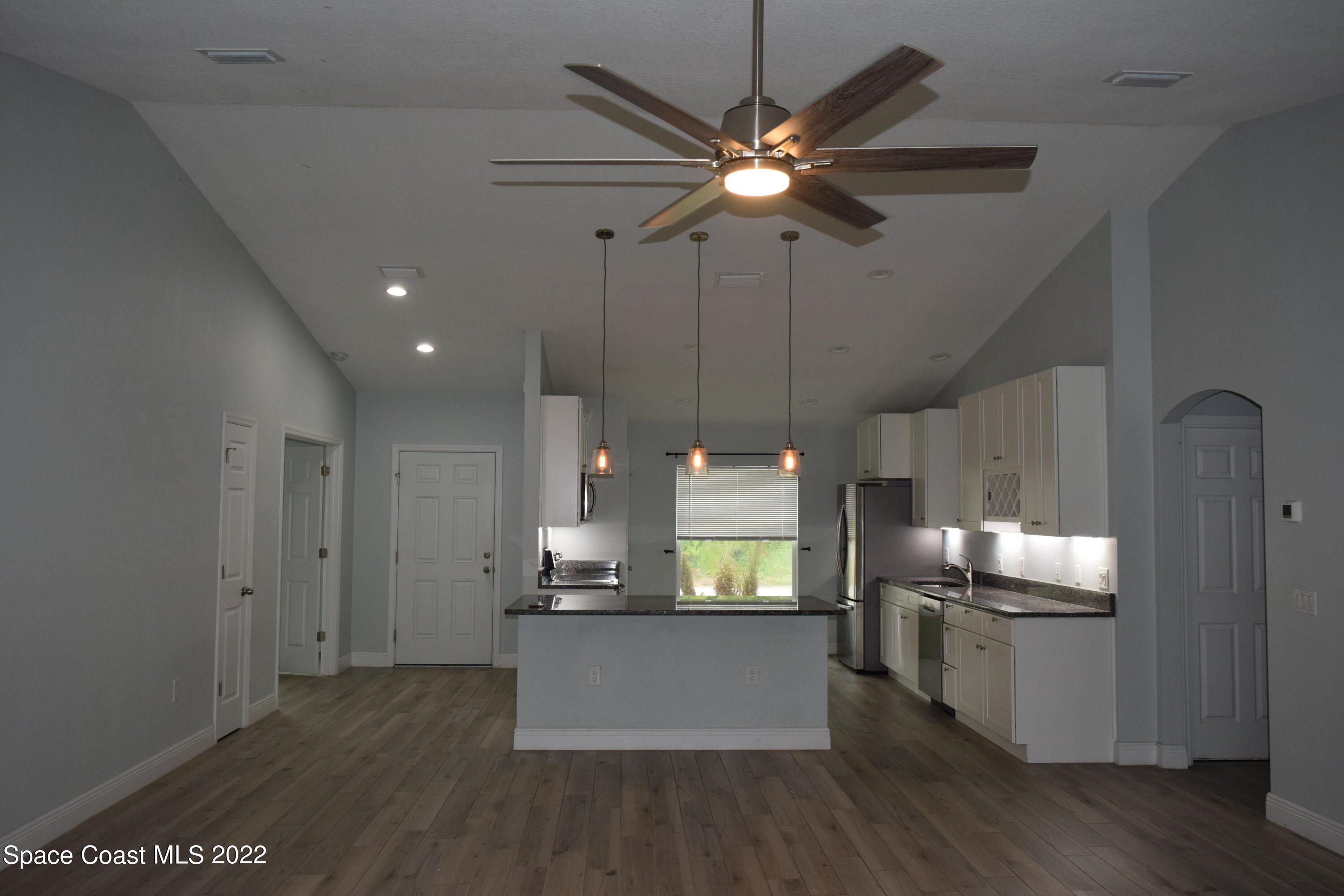 1328 Hazel Street Northwest Palm Bay, FL 32907 - Photo 3 of 28 a view of a kitchen with a sink wooden floor and an empty room