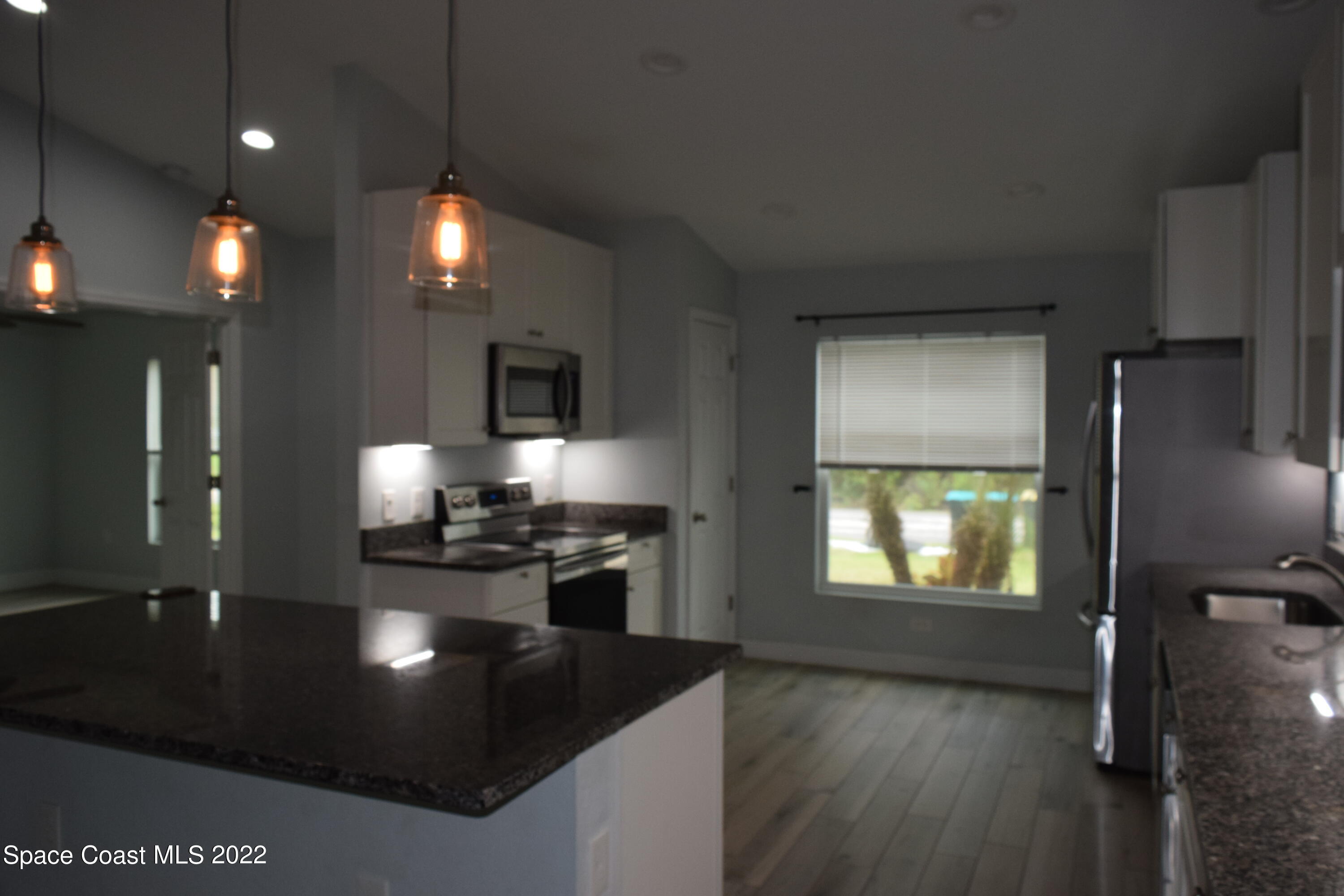 1328 Hazel Street Northwest Palm Bay, FL 32907 - Photo 4 of 28 a kitchen with stainless steel appliances granite countertop a stove a sink and a refrigerator