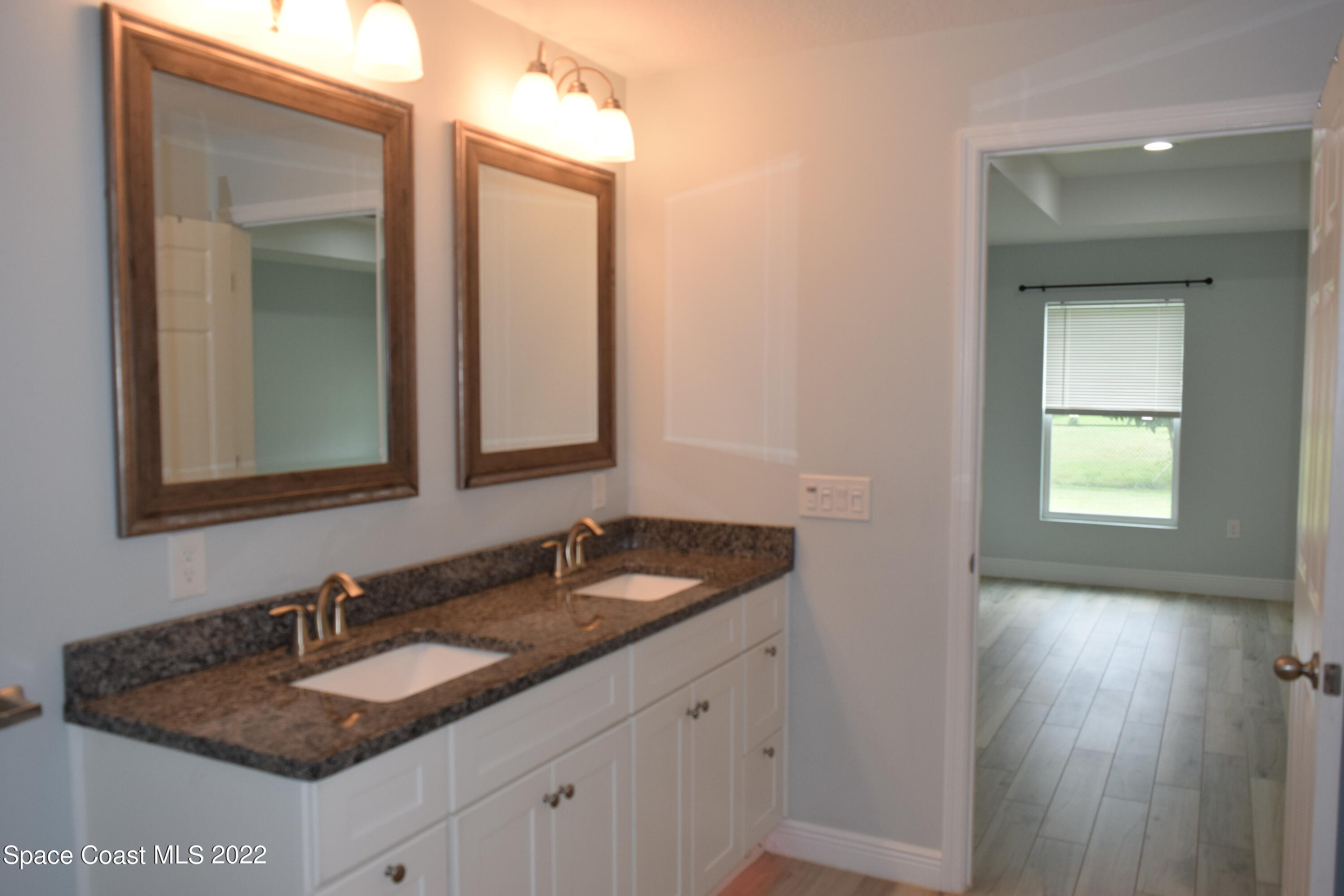 1328 Hazel Street Northwest Palm Bay, FL 32907 - Photo 10 of 28 a bathroom with a granite countertop sink and a mirror