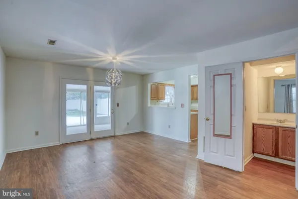 a view of an empty room with window and wooden floor