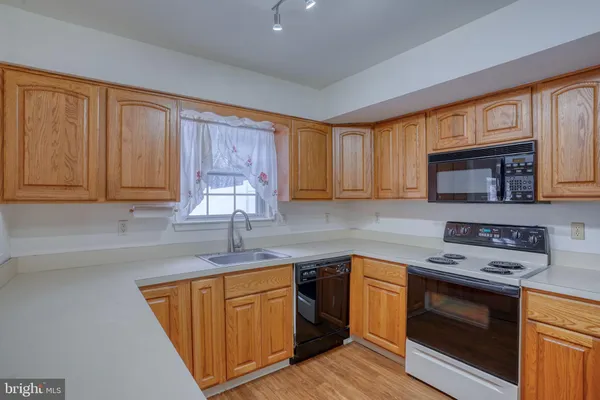 a kitchen with a sink stove top oven and cabinets