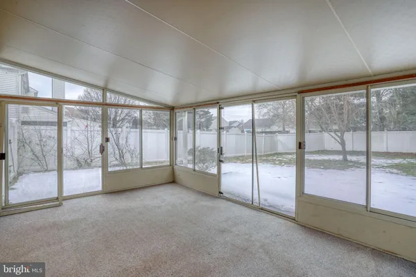 en empty room with windows and chandelier fan