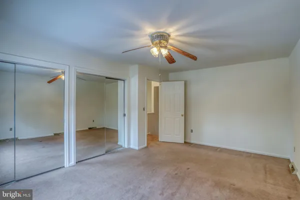 a bathroom with a granite countertop sink a toilet and a mirror