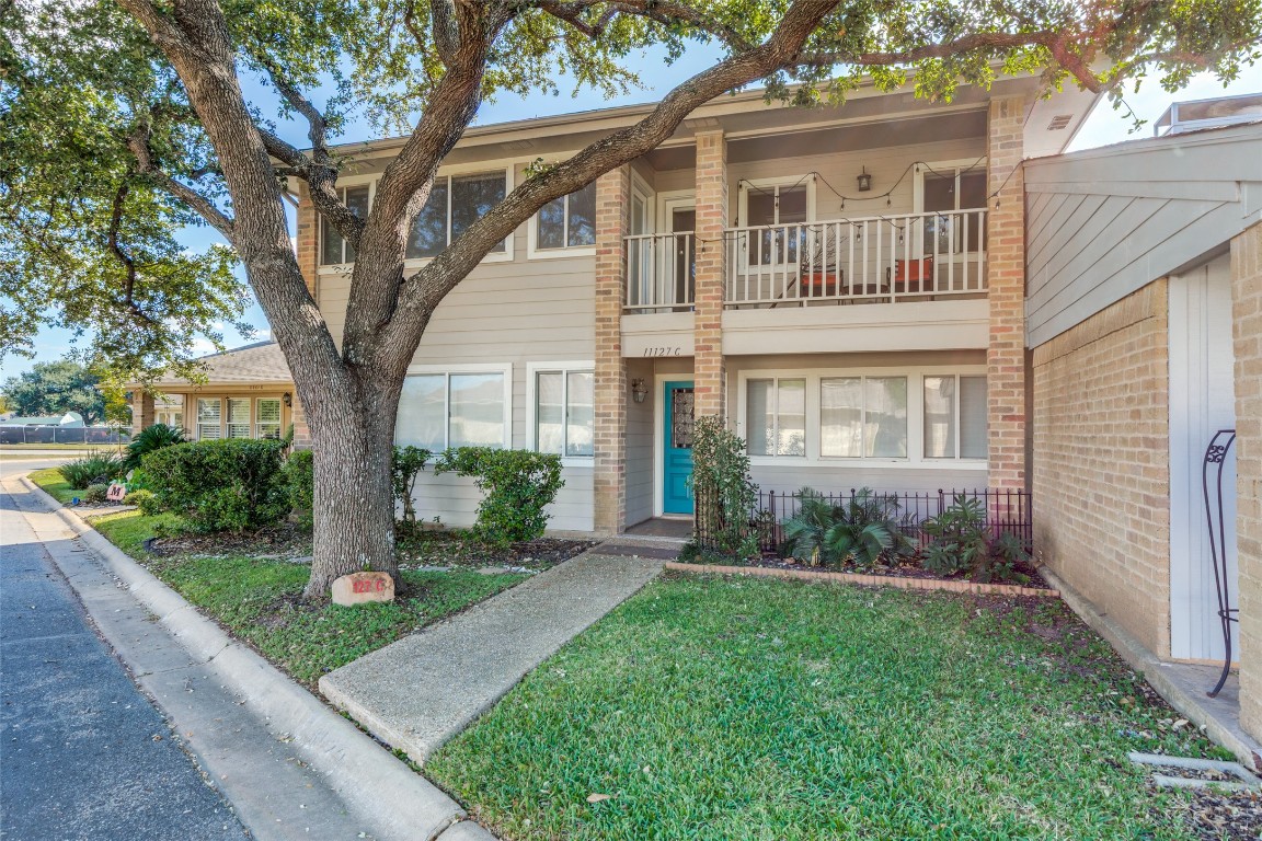 11127 Pinehurst Drive, Unit C Austin, TX 78747 - Photo 1 of 25 a view of a brick house with a yard and plants