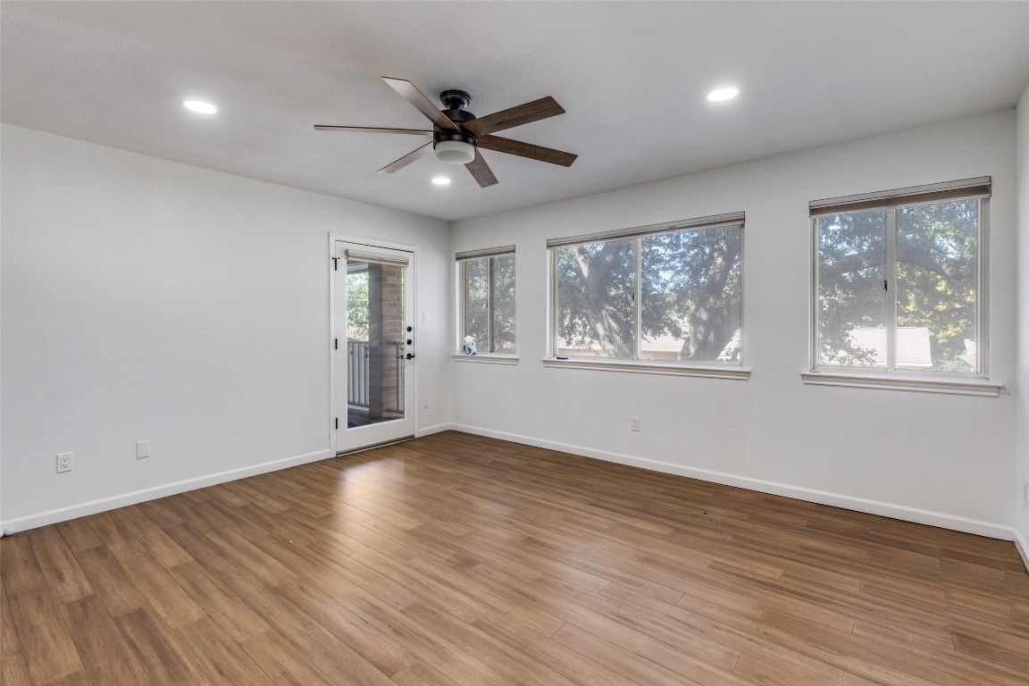 11127 Pinehurst Drive, Unit C Austin, TX 78747 - Photo 16 of 25 a view of an empty room with wooden floor and a window