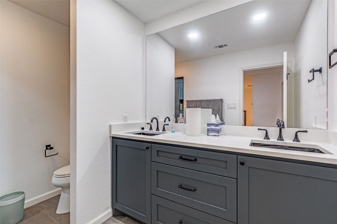 11127 Pinehurst Drive, Unit C Austin, TX 78747 - Photo 17 of 25 a bathroom with a double vanity sink toilet and a mirror