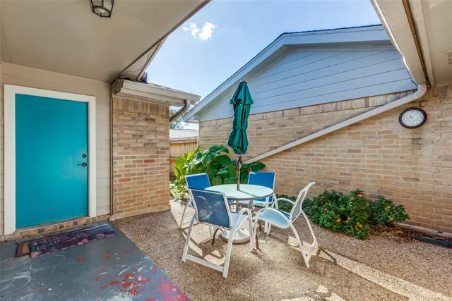 a view of a patio with table and chairs and potted plants