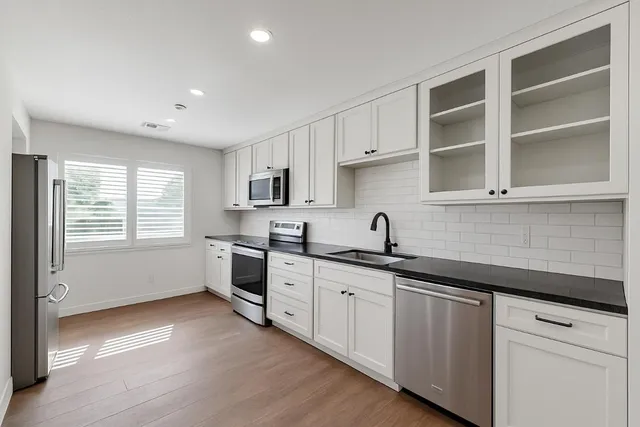 a kitchen with granite countertop white cabinets and white appliances