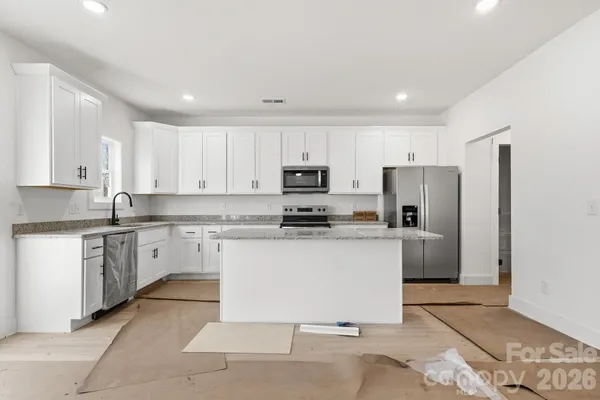 a kitchen with stainless steel appliances granite countertop a refrigerator sink and stove