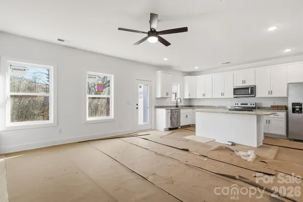 a view of kitchen with granite countertop stove top oven and cabinets