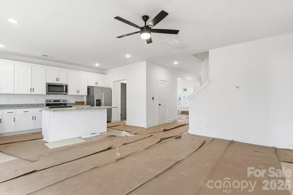a view of kitchen with stainless steel appliances refrigerator stove microwave and cabinets