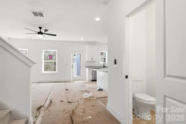 a view of a hallway with bathroom and a toilet