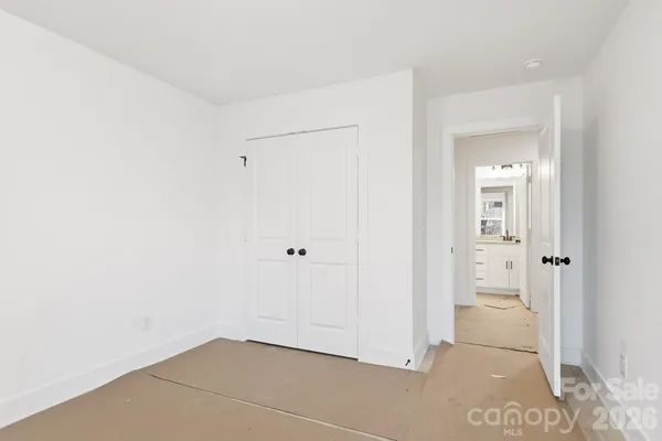 a bathroom with a granite countertop sink a toilet a mirror and shower