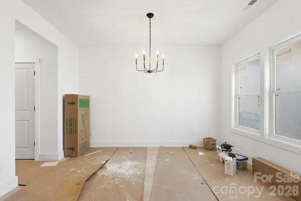 a view of a room with a chandelier fan and windows