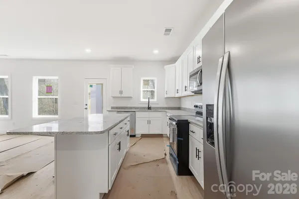 a kitchen with white cabinets and stainless steel appliances