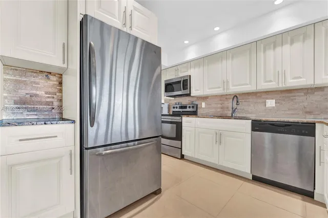 a kitchen with cabinets stainless steel appliances and a counter top space