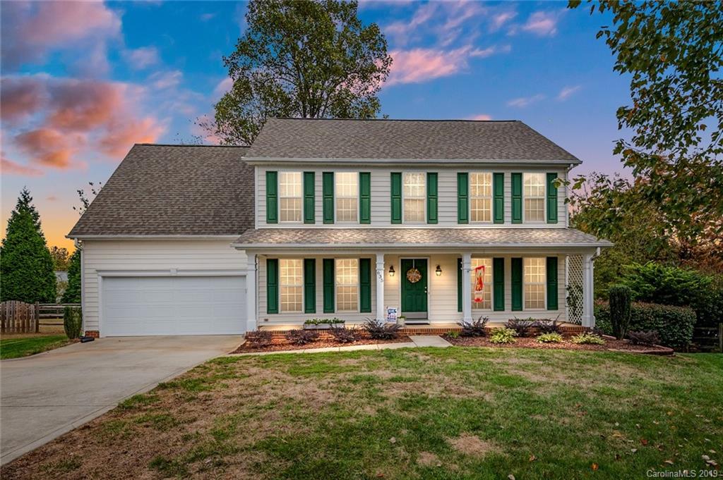 a front view of a house with yard and green space