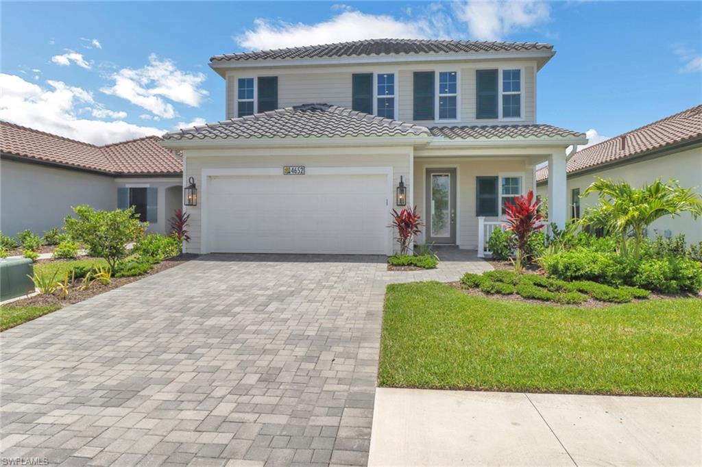 4652 Centaurus Circle Naples, FL 34120 - Photo 1 of 45 Mediterranean / spanish-style house featuring a garage, a tile roof, decorative driveway, and a porch