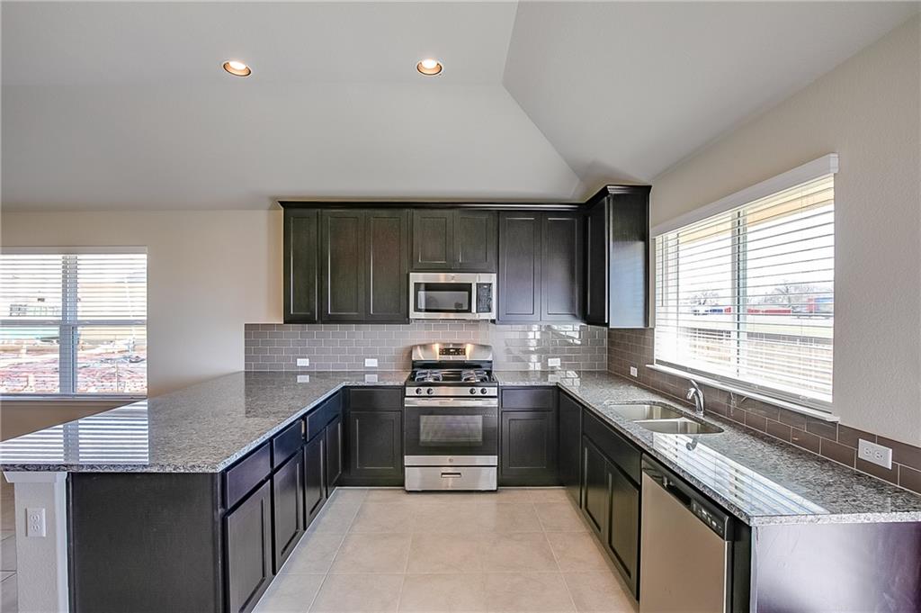 306 Delta Crest Maxwell, TX 78656 - Photo 10 of 24 a kitchen with kitchen island granite countertop a sink stove and refrigerator