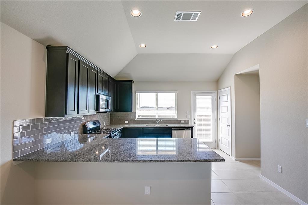 306 Delta Crest Maxwell, TX 78656 - Photo 8 of 24 a large kitchen with granite countertop a large window and a sink