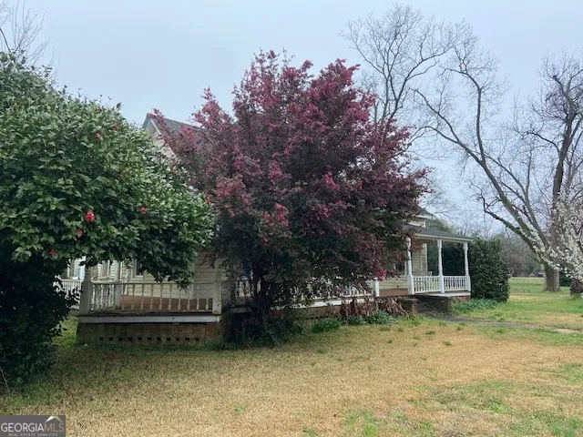 a view of a house with a tree next to a yard