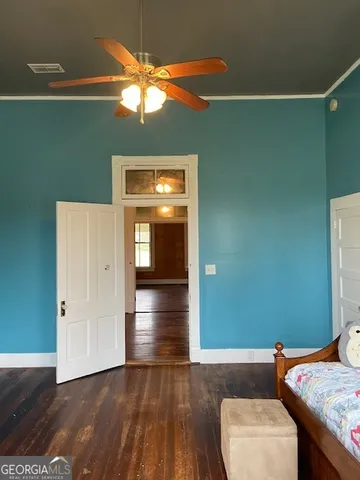 a view of a livingroom with wooden floor and a ceiling fan
