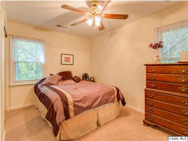 89 West Daffodil Road Ruckersville, VA 22968 - Photo 21 of 22 a bedroom with a bed and a chandelier