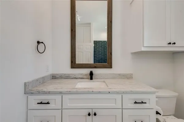 a bathroom with a granite countertop sink and a mirror