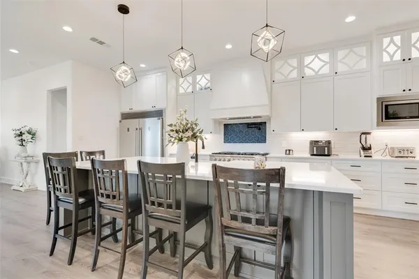 an empty room with chandelier fan and windows