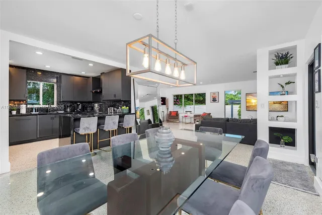 a living room with fireplace furniture and a view of kitchen