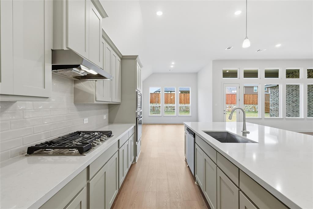 556 Flint Road Waxahachie, TX 75167 - Photo 21 of 39 a kitchen with stainless steel appliances granite countertop a sink stove and cabinets