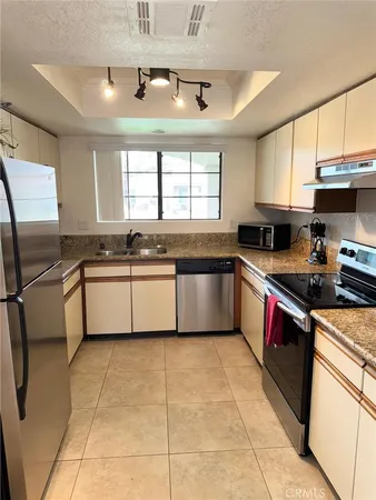 a kitchen with stainless steel appliances granite countertop a sink counter space cabinets and a window