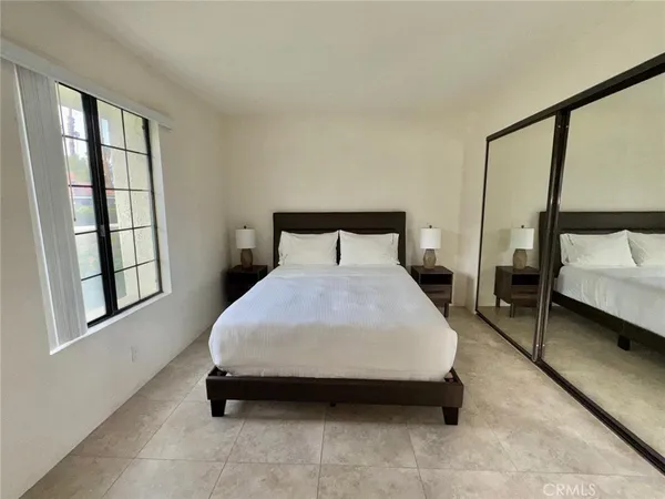a spacious bedroom with a bed and a window