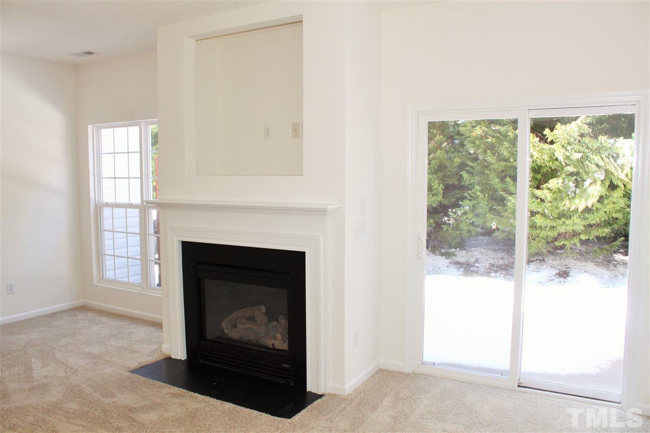 3043 Settle In Lane Raleigh, NC 27614 - Photo 8 of 19 a living room with a fireplace and a window