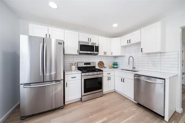a kitchen with stainless steel appliances a refrigerator sink and microwave