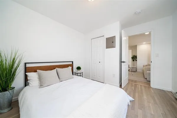 a bedroom with a bed and a potted plant