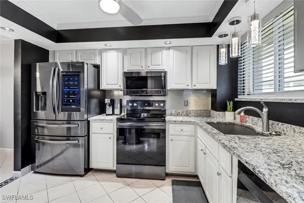 a kitchen with stainless steel appliances granite countertop a refrigerator sink and stove