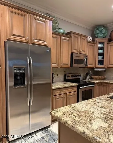 a kitchen with stainless steel appliances granite countertop a refrigerator a stove and a sink