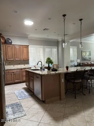 a kitchen with stainless steel appliances kitchen island granite countertop a sink a counter top space and cabinets