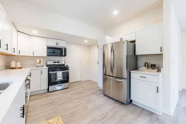a kitchen with a refrigerator stove and wooden cabinets