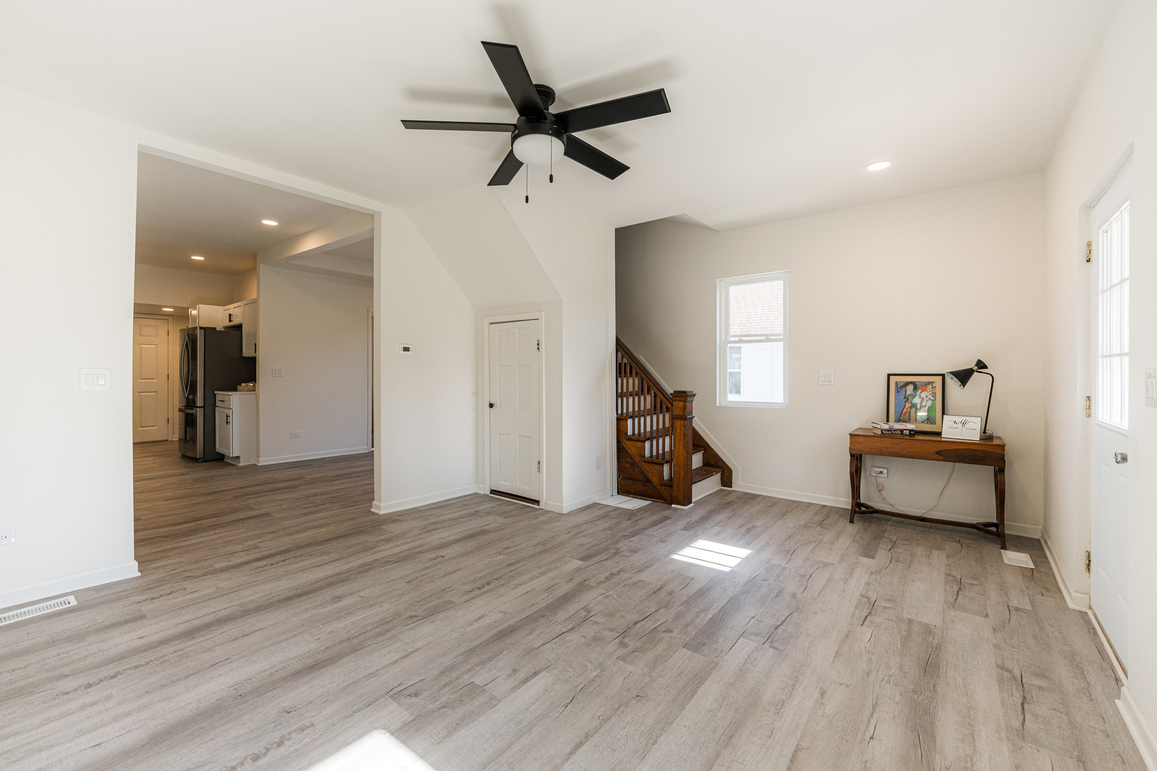 615 Prospect Street DeKalb, IL 60115 - Photo 3 of 27 a view of a livingroom with wooden floor and a ceiling fan