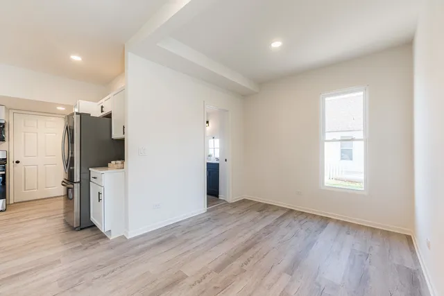 a view of empty room with wooden floor and window
