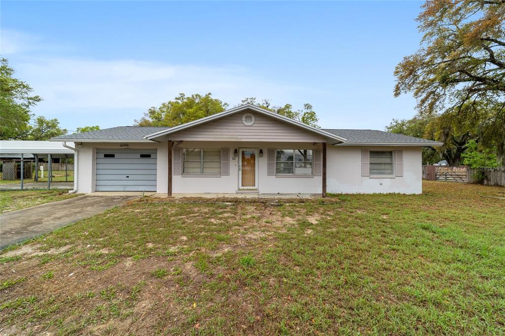10496 Southeast Sunset Harbor Road Summerfield, FL 34491 - Photo 1 of 1 a front view of a house with a garden