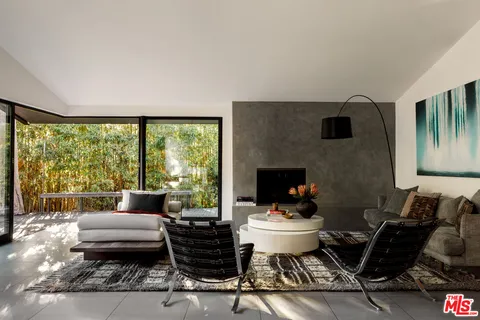 a living room with furniture and a floor to ceiling window