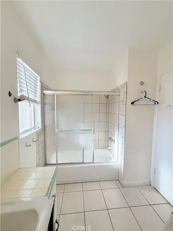 a large white kitchen with a stove a sink and a cabinets