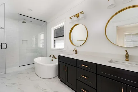 a spacious bathroom with a double vanity sink mirror and bathtub
