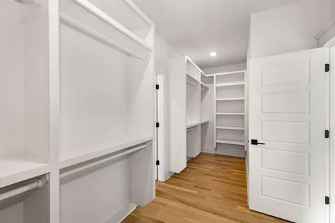 a view of walk in closet with wooden floor